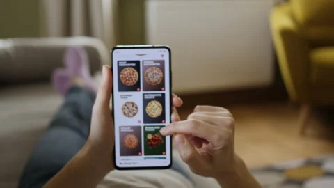 Orders Pizza Using Online Delivery. Woman Orders Food Home In Online Store Us Stock Footage 161099181