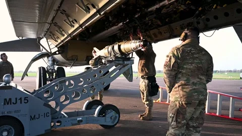 Ordnancemen using a bomb loader to load a GBU-38 JDAM onto a B-52 Stratofortress Stock Footage 293060591