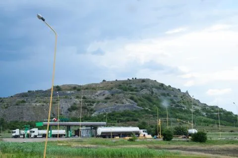Ore slag dumps after processing. Old stepped terricon in form of a hill with  Stock Photos