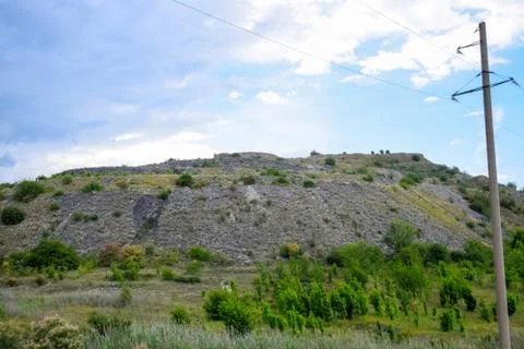 Ore slag dumps after processing. Old stepped terricon in form of a hill with  Stock Photos