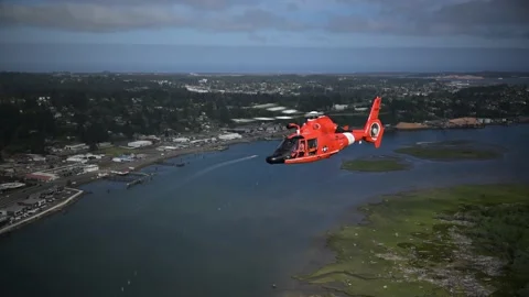 OREGON - 5.9.2025 - A US Coast Guard helicopter flies along a busy riverbank in Stock-Footage 312863772