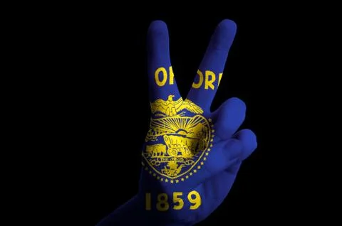 Oregon us state flag two finger up gesture for victory and winner symbol made Stock Photos