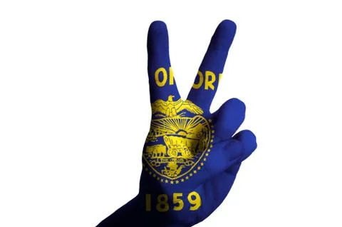 Oregon us state flag two finger up gesture for victory and winner symbol made Stock Photos