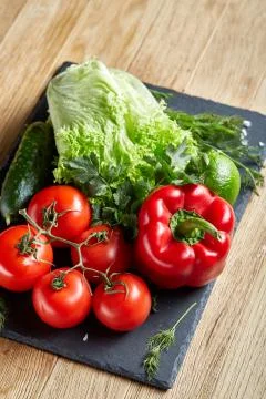 Organic closeup still life of assorted fresh vegetables and herbs on rustic Stock Photos