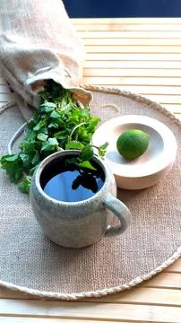 Organic coffee in rustic ceramic cup, f mint leaves scattered across surface Stock Photos