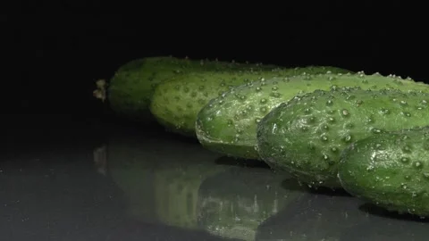 Organic cucumbers close-up. Black background. Fresh vegetables. Stockbeeldmateriaal 144353270