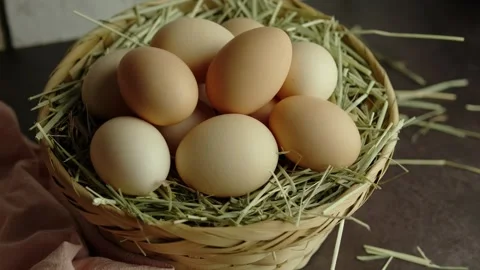 Organic eggs and hay in a wicker basket, Pan right Stock Footage 281036960