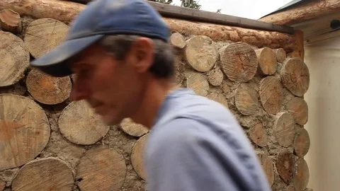 Organic farmer making natural wall with logs and cob mud Stock Footage 80391723