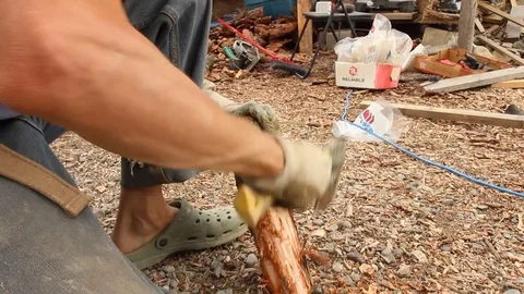 Organic farmer removes bark from log with small axe Stock Footage 80392050