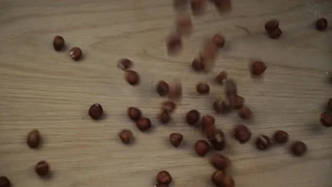 Organic Hazelnuts kernel  falling on wooden background. Slow motion. Stock Footage 130918426