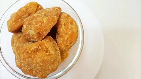 Organic Jaggery or Gur pieces in a glass bowl rotating against a clean white Stock Footage 284106953