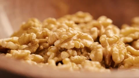 Organic peeled walnut kernels in a rustic wooden dish Stock Footage 248380833