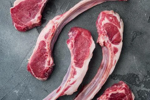 Organic pieces of mutton meat, Rack of lamb , raw with bone, on gray stone ba Stock Photos