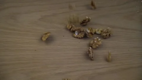 Organic Walnut kernel falling on wooden background. Slow motion.C0090 Stock Footage 130918421