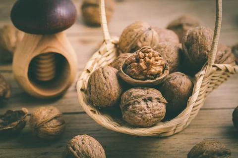 Organic walnuts with small nutcraker as baking ingredients on wooden background Stock Photos