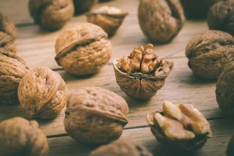 Organic walnuts with small nutcraker as baking ingredients on wooden background Stock Photos