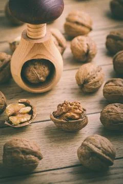Organic walnuts with small nutcraker as baking ingredients on wooden background Stock Photos