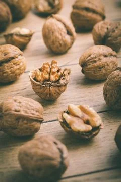Organic walnuts with small nutcraker as baking ingredients on wooden background Stock Photos