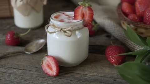 Organic yogurt with strawberries in a glass jar. Stock Footage