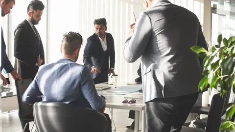 Organization collaboration. Companions sitting down on chairs around the table Stock Footage 166609715