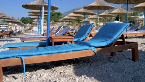 Organized beach area with sunbeds and umbrellas on pebble shore. Stock-Footage 334039794