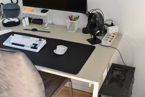 Organized computer desk setup with keyboard mouse monitor headphones home Foto stock
