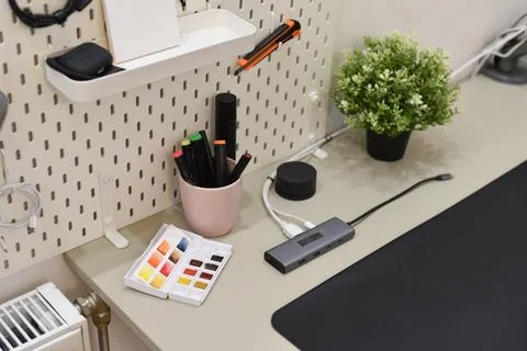 Organized desk setup displays tools accessories on white pegboard high-angle Foto stock