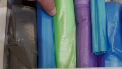 Organized Essentials: Hand Selects a Colorful Garbage Bag from a Tidy Drawer Stock Footage 318782873