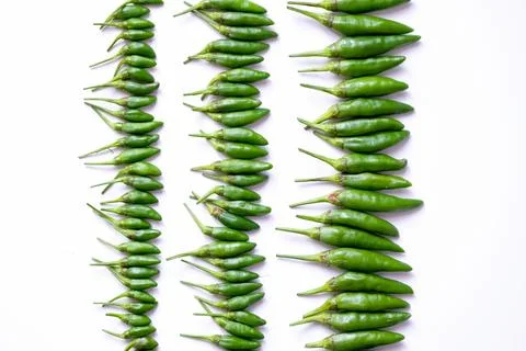 Organized horizontal rows of fresh green bird's eye chilies or cabe rawit hijau Stock Photos