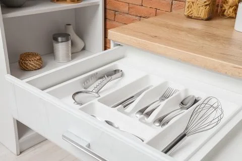 Organized kitchen drawer with silverware and utensils, modern home storage so Stock Photos