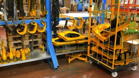 Organized storage rack with yellow lifting hooks and chains in a warehouse Stock Footage 328644909