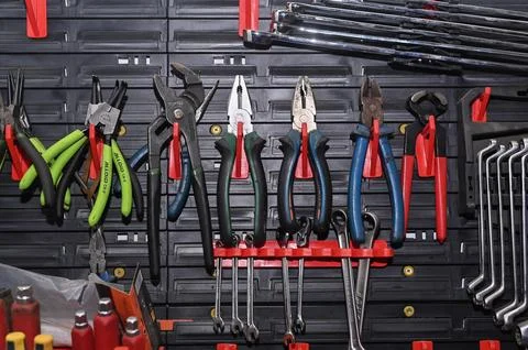 Organized tool rack holds various pliers and spanners in workshop garage. 스톡 사진