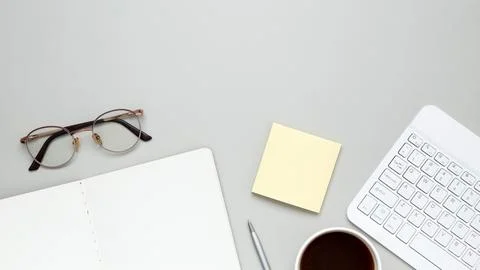 Organized workspace featuring keyboard, glasses, notebook, and stationery sup Stock-Fotos