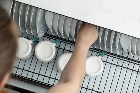 Organizing Clean Dishware in a Modern Kitchen After a Meal Preparation Session Stock Photos
