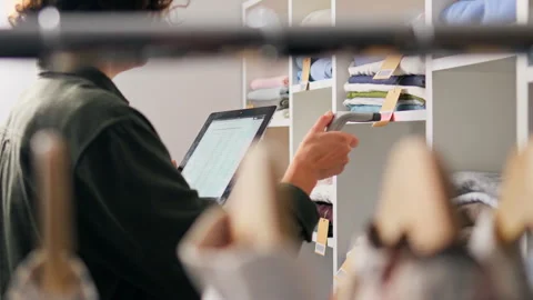 Organizing inventory in a clothing store using a digital tablet during the w Stock Footage 323713019