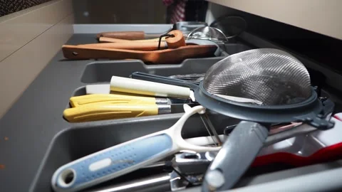 Organizing kitchen tools in a cluttered drawer Stock Footage 318502651