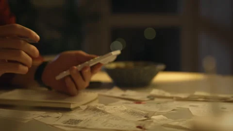 Organizing receipts and documents at a cluttered desk in the evening Stock Footage 323868073