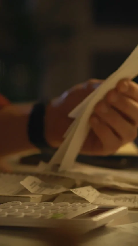 Organizing receipts and notes on a dimly lit table in the evening Stock Footage 331668878