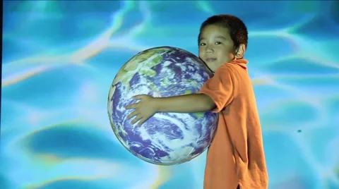 Oriental  boy hugs globe of Planet Earth, water ripples in Back Ground Stock Footage 45524082