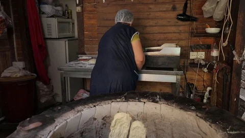 Oriental bread is cooked in tandoor. Closeup the dough on the walls of the oven Stock Footage 123317376