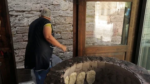 Oriental bread is cooked in tandoor. Closeup the dough on the walls of the oven Stock Footage 123317417