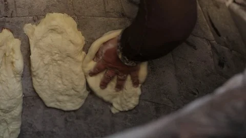Oriental bread is cooked in tandoor. Closeup the dough on the walls of the oven Stock Footage 123356808