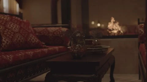 Oriental Lounge with Red Cushions, Open Fire in Background, Warm Evening Light Stock Footage 341295202