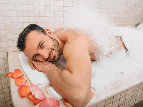 Oriental man looking into the frame during a foamy massage in a hammam . Trad Stockfoto's