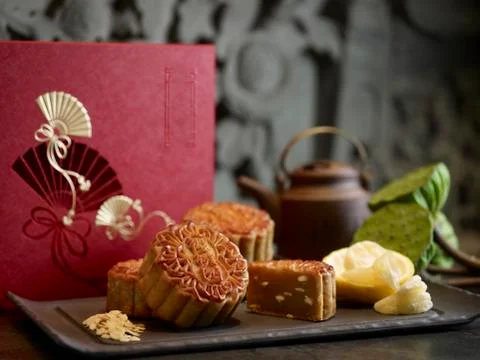 Oriental mooncake with silver lotus paste yuzu and melon seeds on black platt Stock Photos