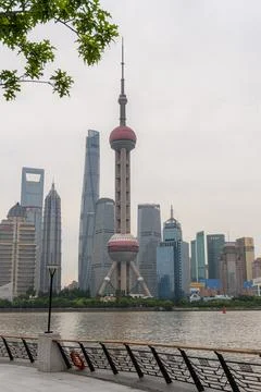 Oriental pearl tower behind the trees at the riverfront in Shanghai Stock Photos