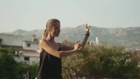 Oriental practice: a young woman does a qigong exercise Stock Footage 257669607