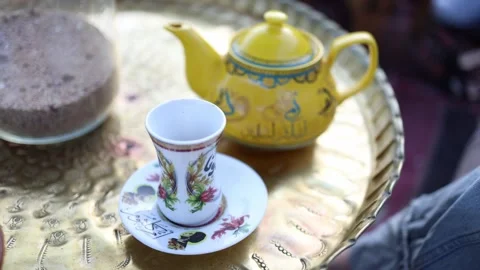 Oriental tea time golden tray painted yellow teapot floral glass cup traditional Stock Footage 310820151