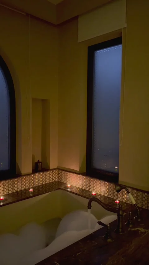 Oriental-themed bathroom with luxurious bubble-filled bathtub, running tap water Stock-Footage 281208191