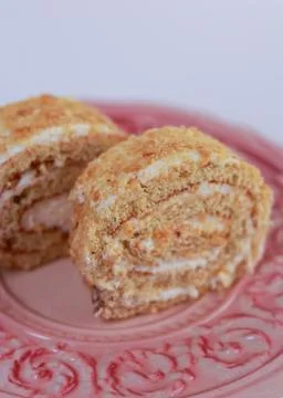 Oriented Swiss roll cake slice, emphasizing its tight spiral of tender sponge Stock Photos